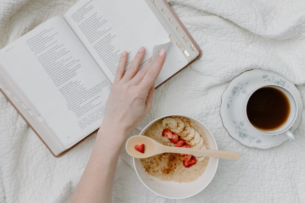 A Person Having Breakfast While Reading a Book